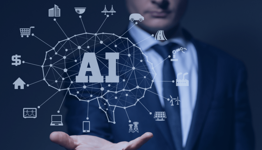  Homem representando um empresário com projeção em holograma em sua mão de um cérebro conectado a vários ícones como: computador, dinheiro, comércio, estrada, entre outros. No centro da imagem as inicias AI, Inteligência Artificial. 